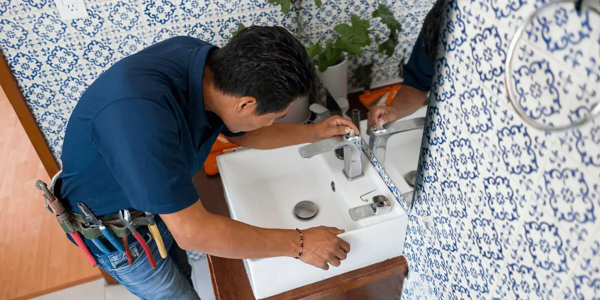 Plumber fixing bathroom sink faucet