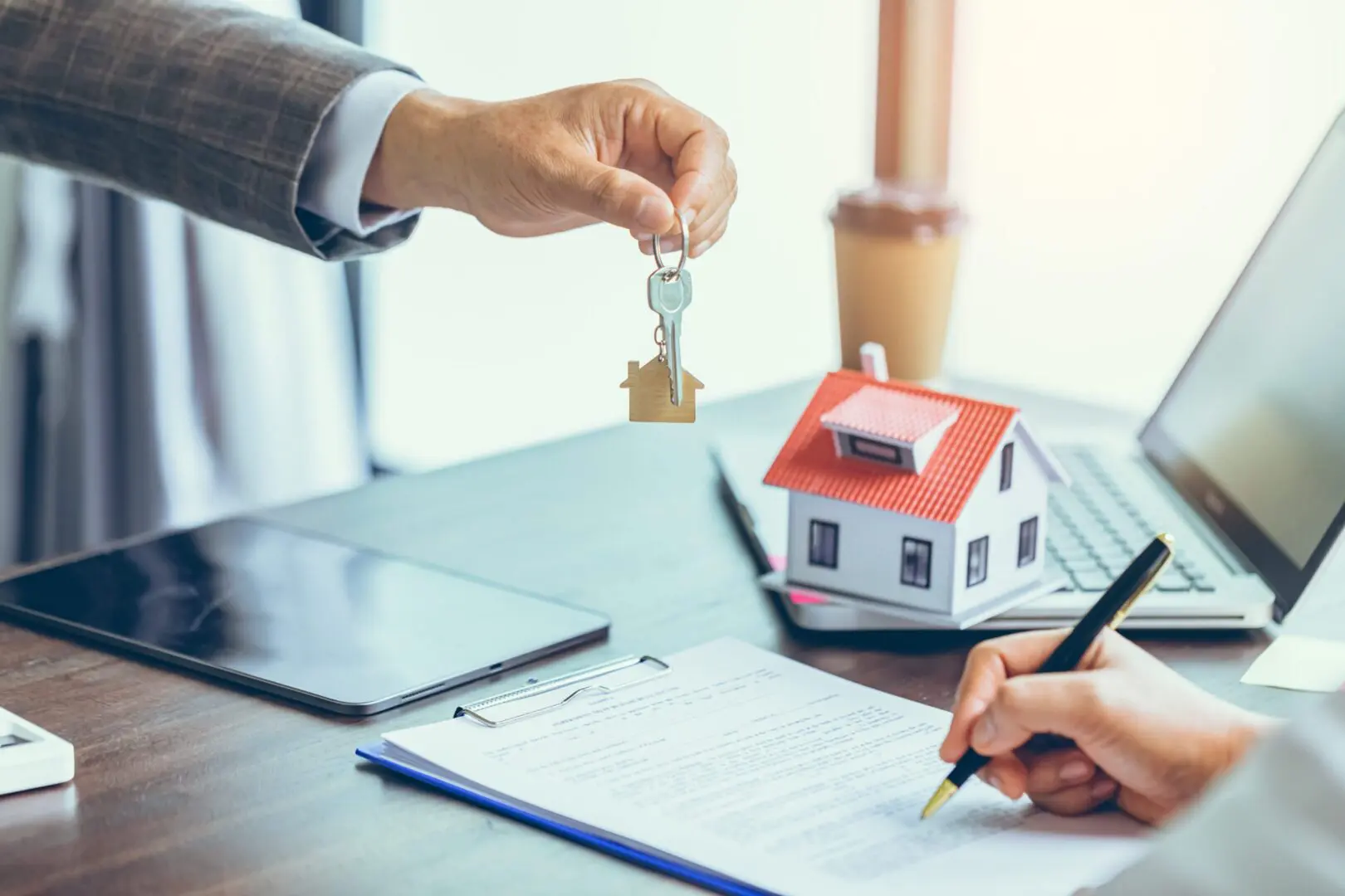 Person handing house key during contract signing