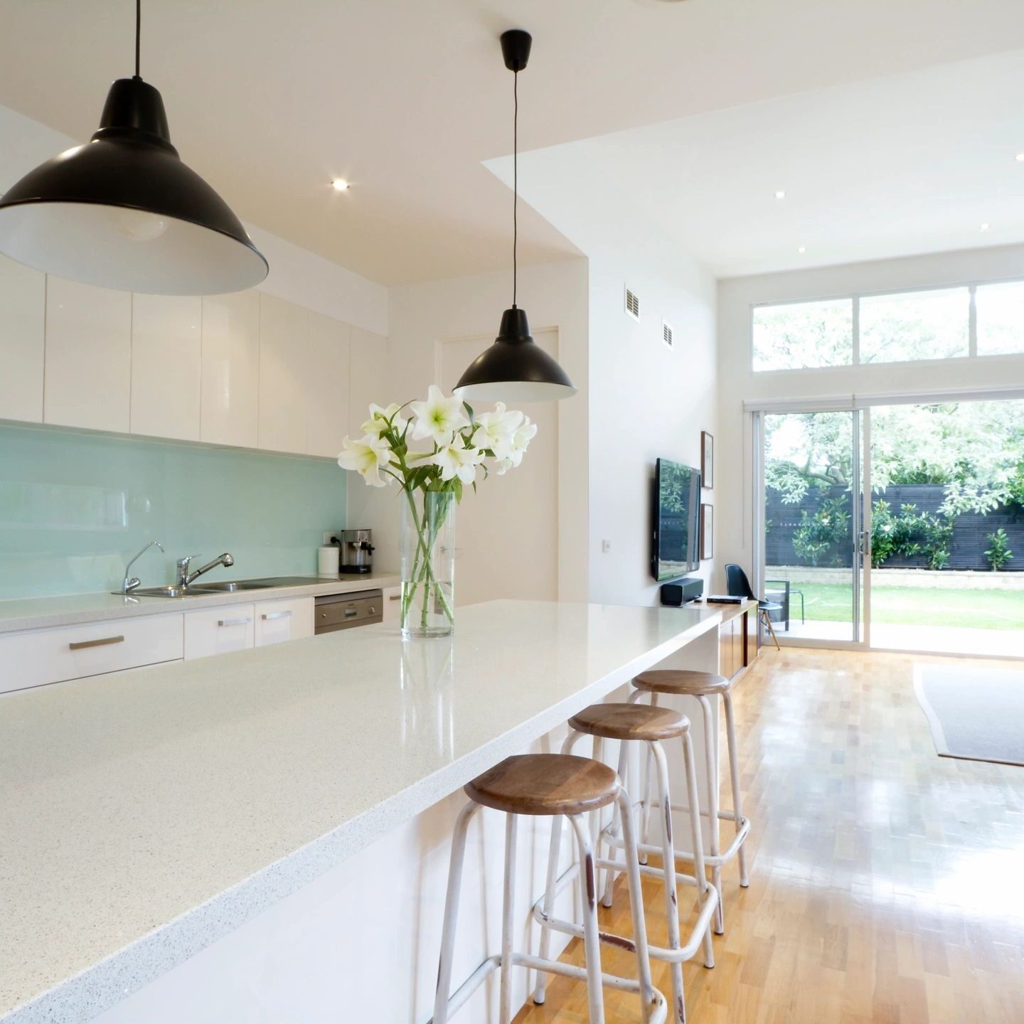 Bright modern kitchen island overlooking backyard